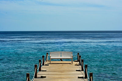 Empty pier over sea against sky