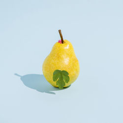 Summer like pear fruit with fig leaf isolated on a yellow background. abstract. square layout