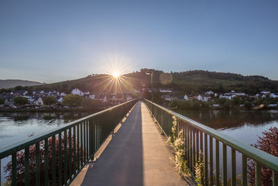 Footbridge over water against sky