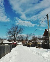 Snow covered houses and trees against sky