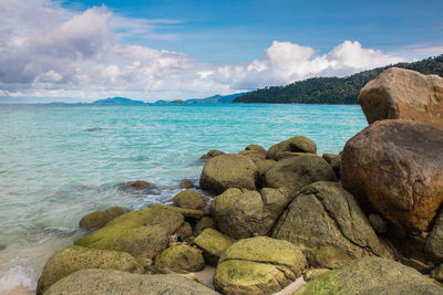 Rocks on sea shore against sky