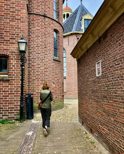 Rear view of a woman walking through the old centre of assen, capital of the dutch drenthe province