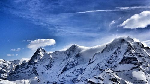 Low angle view of snowcapped mountains against sky on sunny day