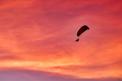 Silhouette of person paragliding under a beautiful florida sunset