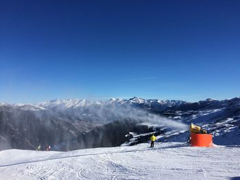 Scenic view of snowcapped mountains against clear blue sky