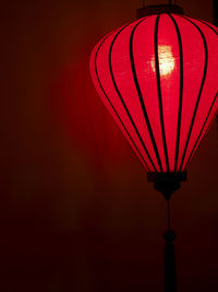 Close-up of illuminated lantern hanging against wall