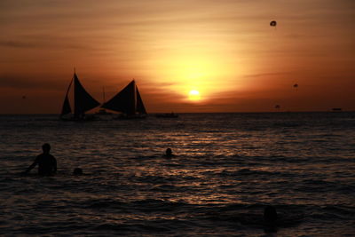 Silhouette person at beach against sky during sunset