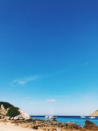 Scenic view of beach against clear blue sky