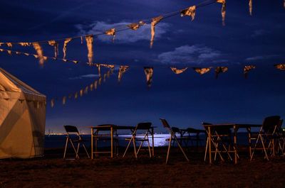 Chairs on beach against sky