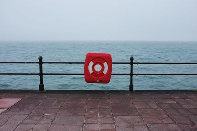 Information sign by sea against clear sky