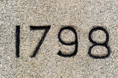 Close-up of text on sand