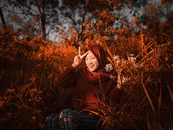 Portrait of smiling young woman on field during autumn