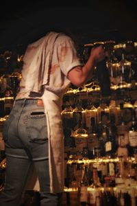 Side view of man drinking glass at night