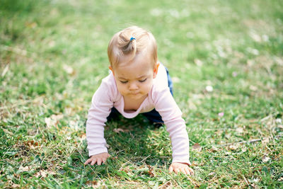 Cute baby girl crawling on grass