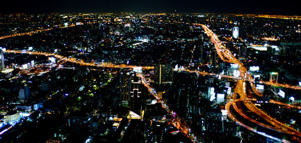 High angle view of city lit up at night