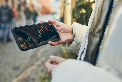 Person investing trading on stock cryptocurrency market using investing application on smartphone