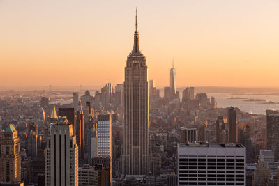 Modern buildings in city against sky during sunset