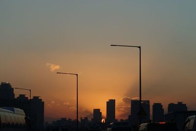 Silhouette city against sky at sunset