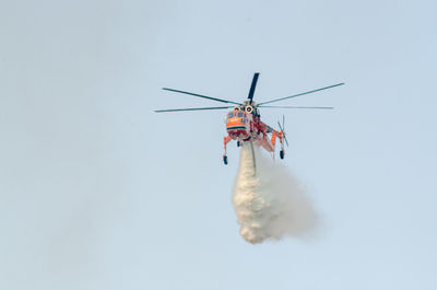 Firefighting helicopter dropping water