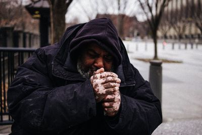 Man sitting on snow covered street