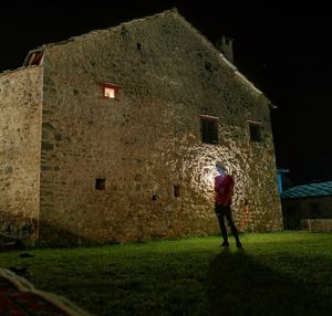 Rear view of man standing on old building