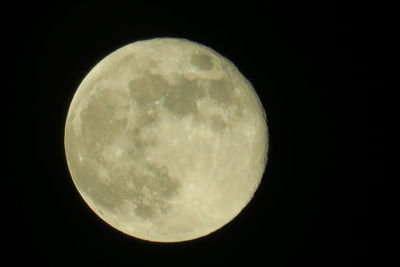 Low angle view of full moon against dark sky
