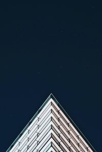 Low angle view of illuminated modern building against clear blue sky