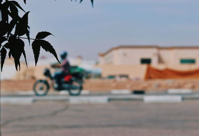 Man riding motorcycle on road in city