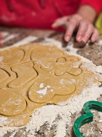 Cropped hand of gingerbread cookies on table