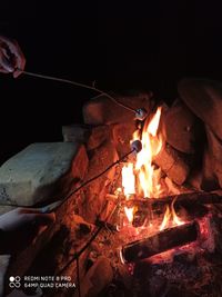 Cropped image of hand holding burning fire