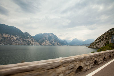 Scenic view of sea by mountains against sky