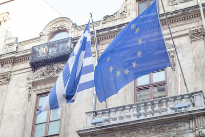 Low angle view of flag against buildings in city