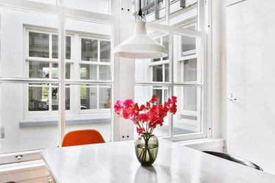 Flower vase on table by window at home