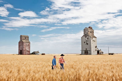 Men standing on field against sky