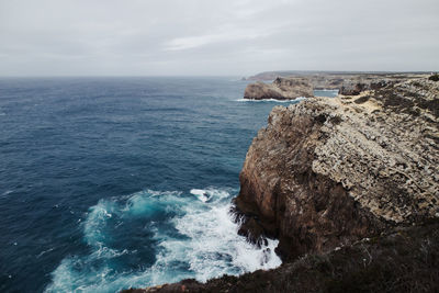 Scenic view of rocks in sea against sky