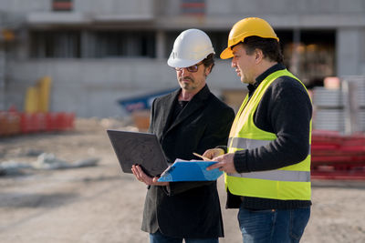 Engineer discussing with construction worker at site