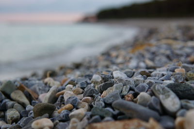 Close-up of pebbles on beach against sky