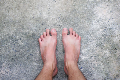 Low section of person standing on sand