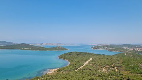 Scenic view of bay against clear blue sky