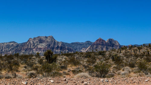 Scenic view of mountains against clear blue sky