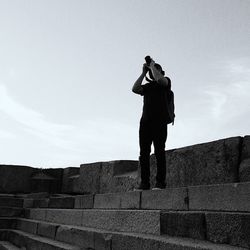 Low angle view of woman standing against sky