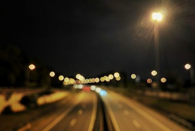 Defocused image of illuminated street lights in city at night