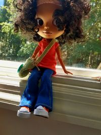 Close-up of boy sitting on tree