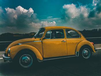 Side view of yellow car on road