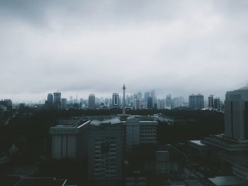 View of cityscape against cloudy sky