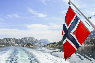 Norwegian flag over sea against sky