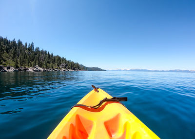 Scenic view of yellow kayak on lake against clear blue sky