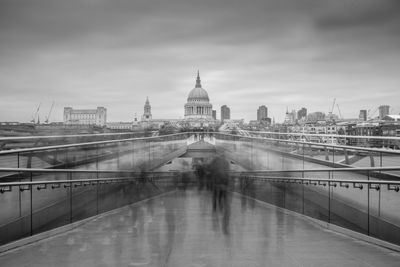 Blurred motion of people walking on london millennium footbridge against st paul cathedral