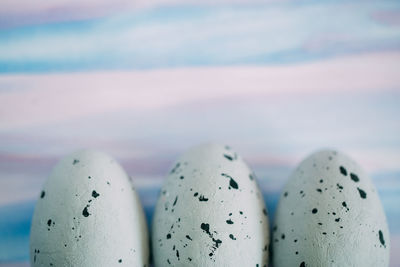 Close-up of quail eggs against colored background