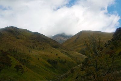 Scenic view of mountains against cloudy sky